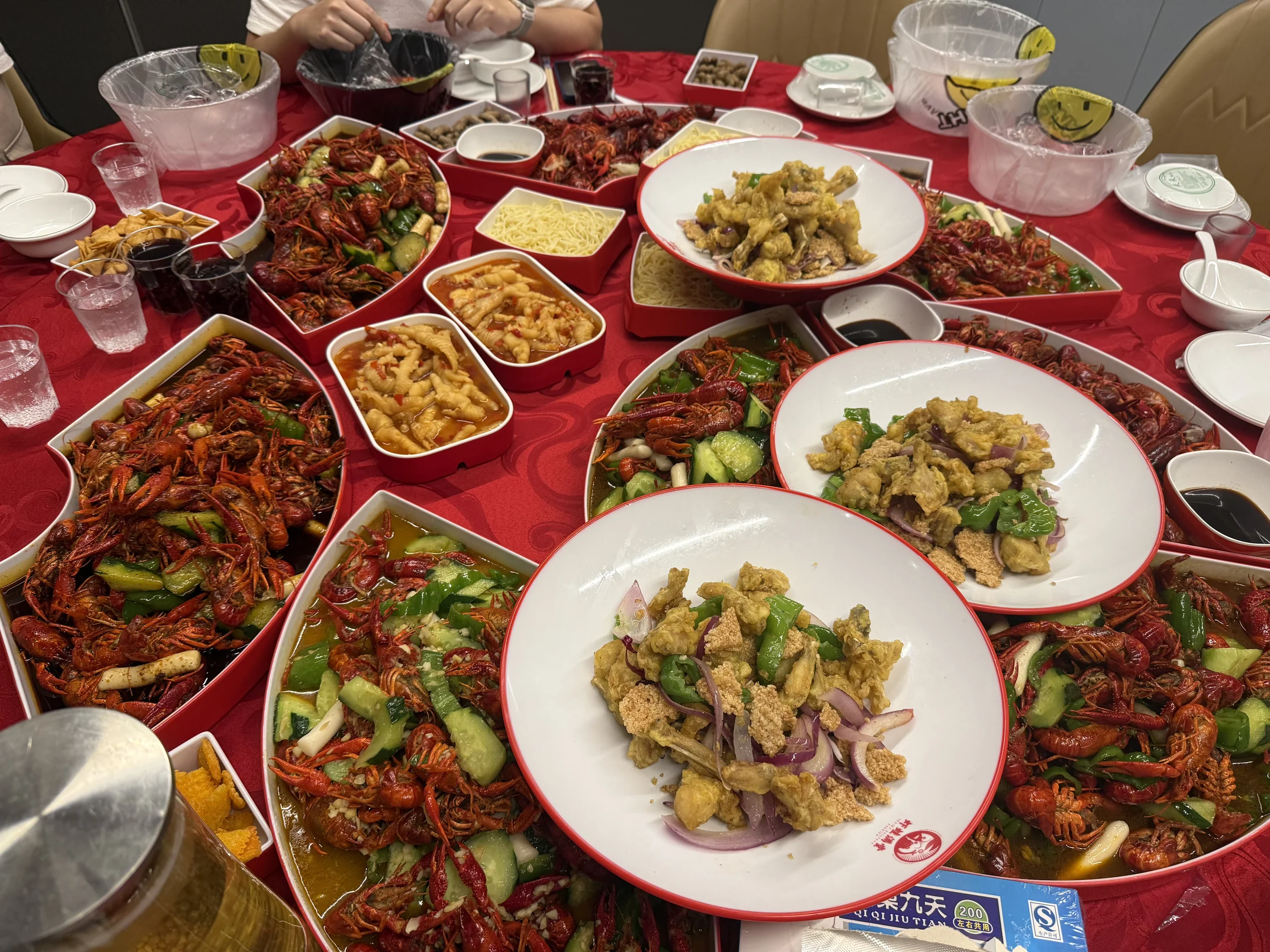 鋪滿成枱嘅小龍蝦同各式炒菜，中間仲疊住一碟菜